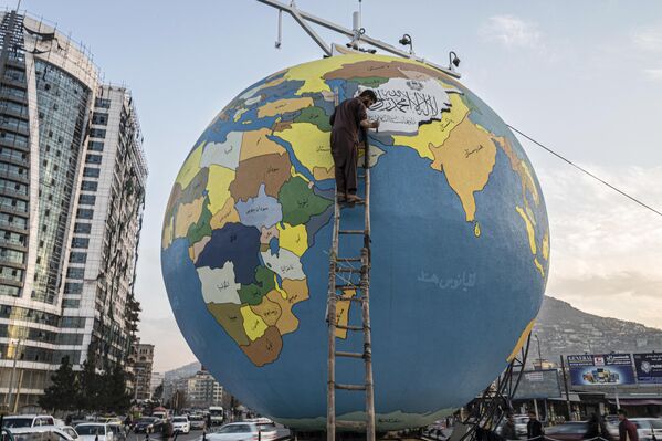Họa sĩ vẽ những nét cuối cùng trên một quả cầu lớn chứa hành tinh Trái đất ở Kabul, Afghanistan. - Sputnik Việt Nam