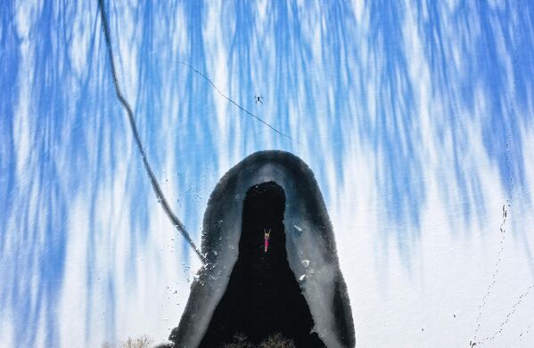 Vận động viên môn bơi mùa đông trong hồ nước đóng băng sau khi tuyết rơi ở Thẩm Dương, thuộc tỉnh Liêu Ninh, đông bắc Trung Quốc. - Sputnik Việt Nam