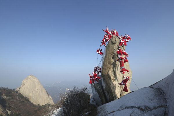 Người leo núi hóa trang thành ông già Noel trên Núi Bakhan ở Seoul, Hàn Quốc. - Sputnik Việt Nam