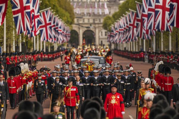 Linh cữu Nữ hoàng Elizabeth II, được trang trí bằng Vương miện Hoàng gia và Vương miện Nữ hoàng, được rước từ Cung điện Buckingham đến Cung điện Westminster ở Luân Đôn. - Sputnik Việt Nam