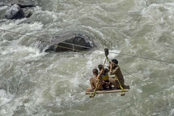 Người dân băng qua con sông đầy sóng gió trong lũ lụt ở Pakistan. - Sputnik Việt Nam