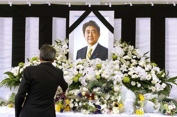 Người đàn ông trước bức chân dung Shinzo Abe trong lễ tang cấp nhà nước của cựu Thủ tướng Nhật Bản Shinzo Abe ở Tokyo. - Sputnik Việt Nam