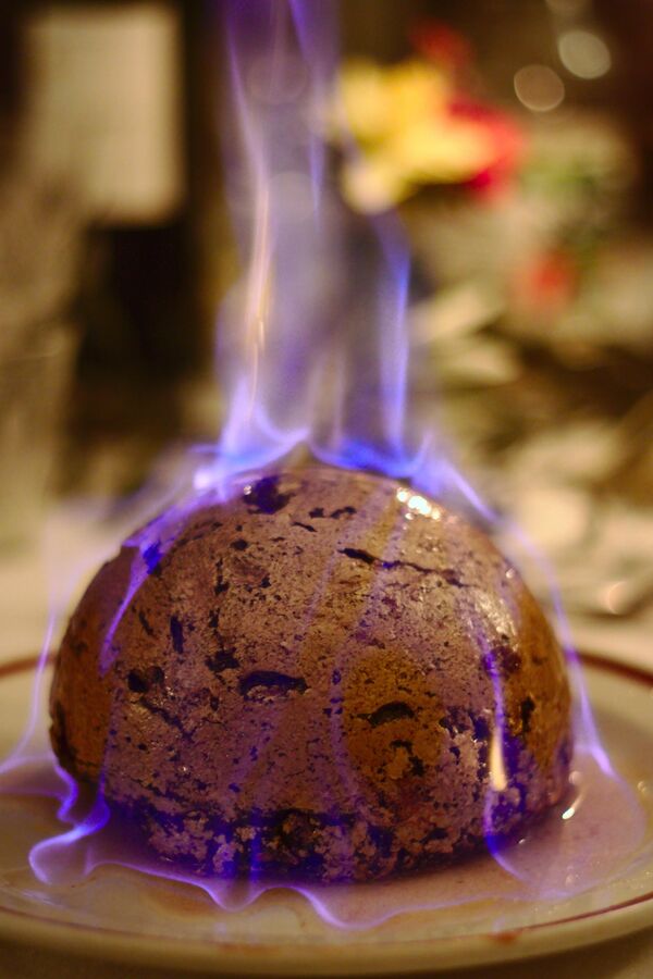 Bánh pudding Giáng sinh, món ăn truyền thống của Anh và Ireland, được đốt lửa trước khi phục vụ. - Sputnik Việt Nam