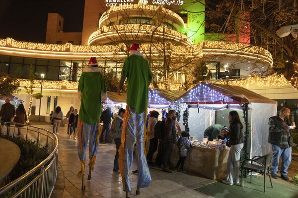 Hai nghệ sĩ đi cà kheo tại chợ Giáng sinh truyền thống bán đồ thủ công ở thành phố Ramallah, bờ Tây sông Jordan. - Sputnik Việt Nam