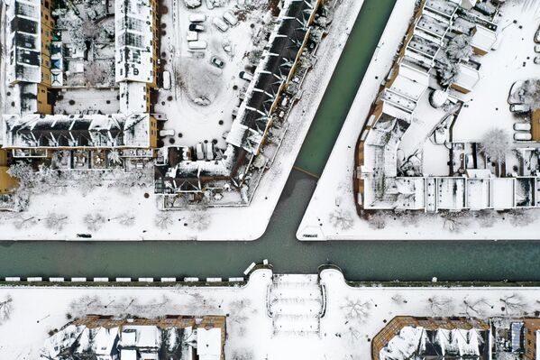 Tuyết bao phủ mái nhà và những con đường xung quanh một con kênh ở Wapping, phía đông London. - Sputnik Việt Nam
