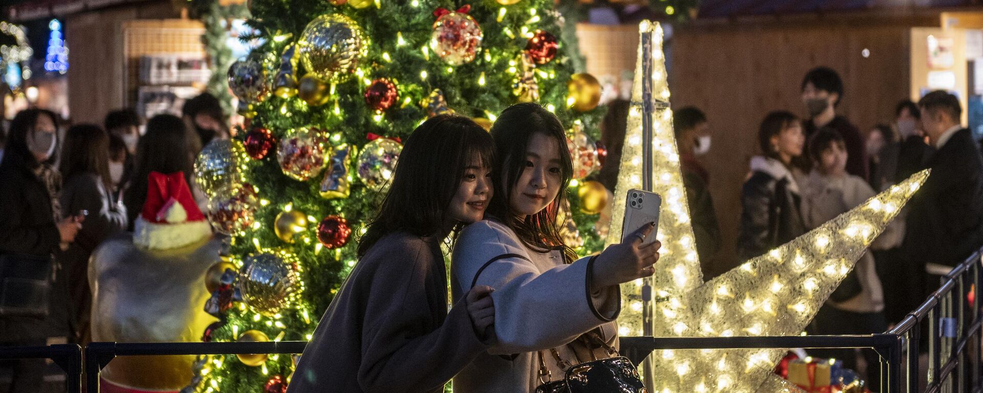 Các cô gái chụp ảnh gần chợ Giáng sinh ở Tokyo, Nhật Bản - Sputnik Việt Nam, 1920, 01.01.2023