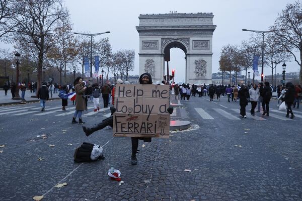 Người đàn ông với tấm biển &quot;Giúp tôi mua một chiếc Ferrari&quot; trước Khải Hoàn Môn ở Paris. - Sputnik Việt Nam
