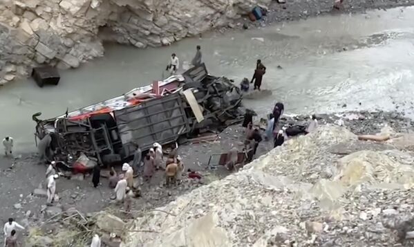 Lực lượng cứu hộ tìm kiếm những người sống sót gần đống đổ nát của xe buýt chở khách đâm vào khe núi ở tây nam Pakistan, ngày 3 tháng 7 năm 2022. - Sputnik Việt Nam