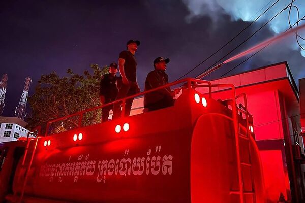Nhân viên cứu hỏa dập lửa tại khách sạn sòng bạc nằm ở phía Campuchia gần cửa khẩu Poipet trên biên giới Thái Lan-Campuchia. - Sputnik Việt Nam