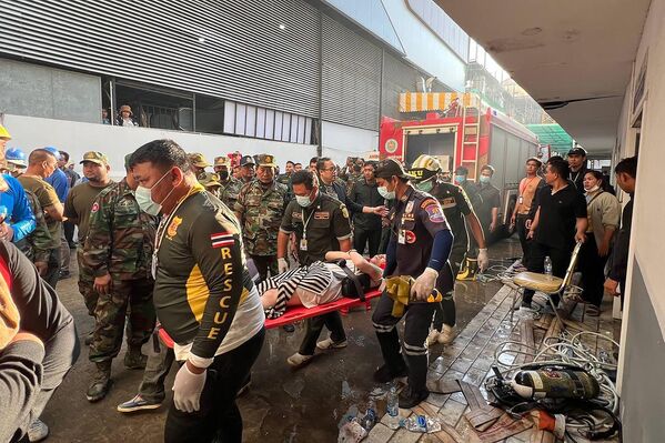 Nhân viên cứu hộ với nạn nhân vụ hỏa hoạn tại khách sạn sòng bạc nằm ở phía Campuchia gần cửa khẩu biên giới Poipet trên biên giới Thái Lan-Campuchia - Sputnik Việt Nam