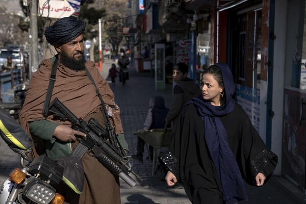 Người phụ nữ nhìn chiến binh Taliban trên đường phố ở Kabul, Afghanistan. - Sputnik Việt Nam