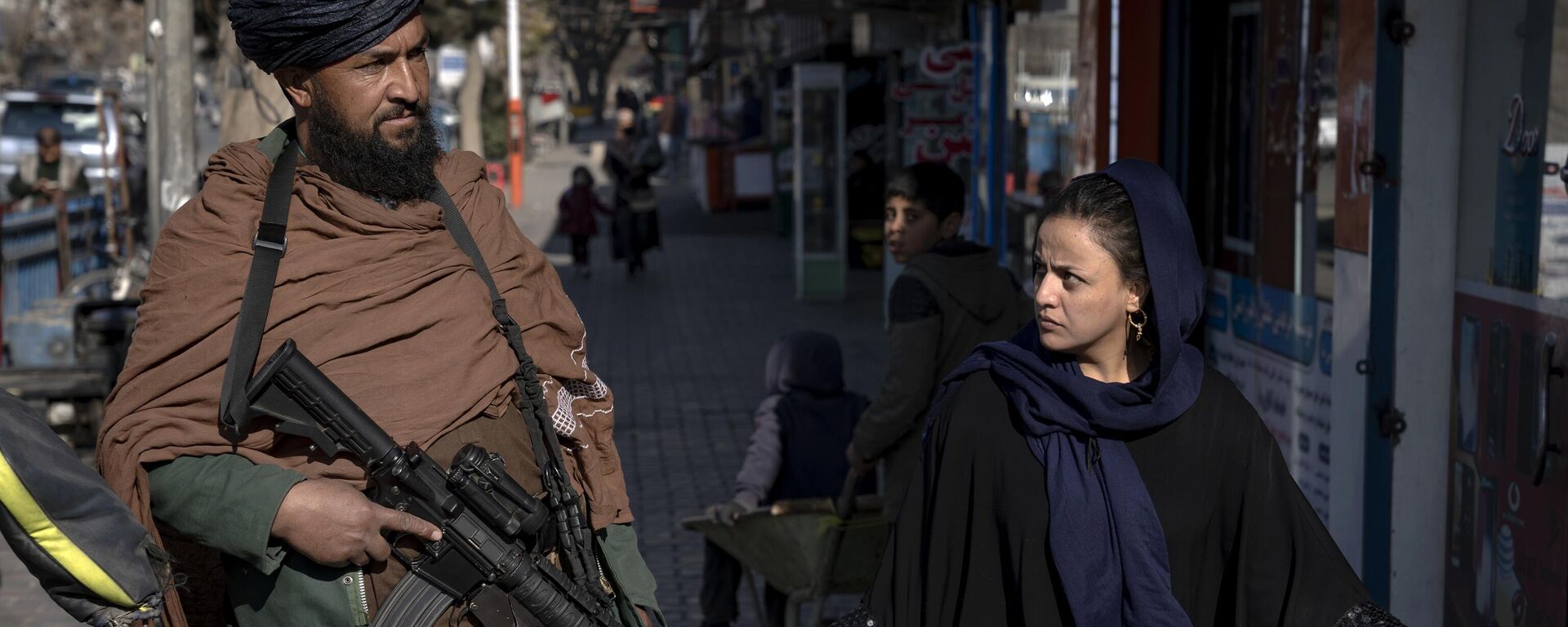 Người phụ nữ nhìn chiến binh Taliban trên đường phố ở Kabul, Afghanistan. - Sputnik Việt Nam, 1920, 25.05.2023