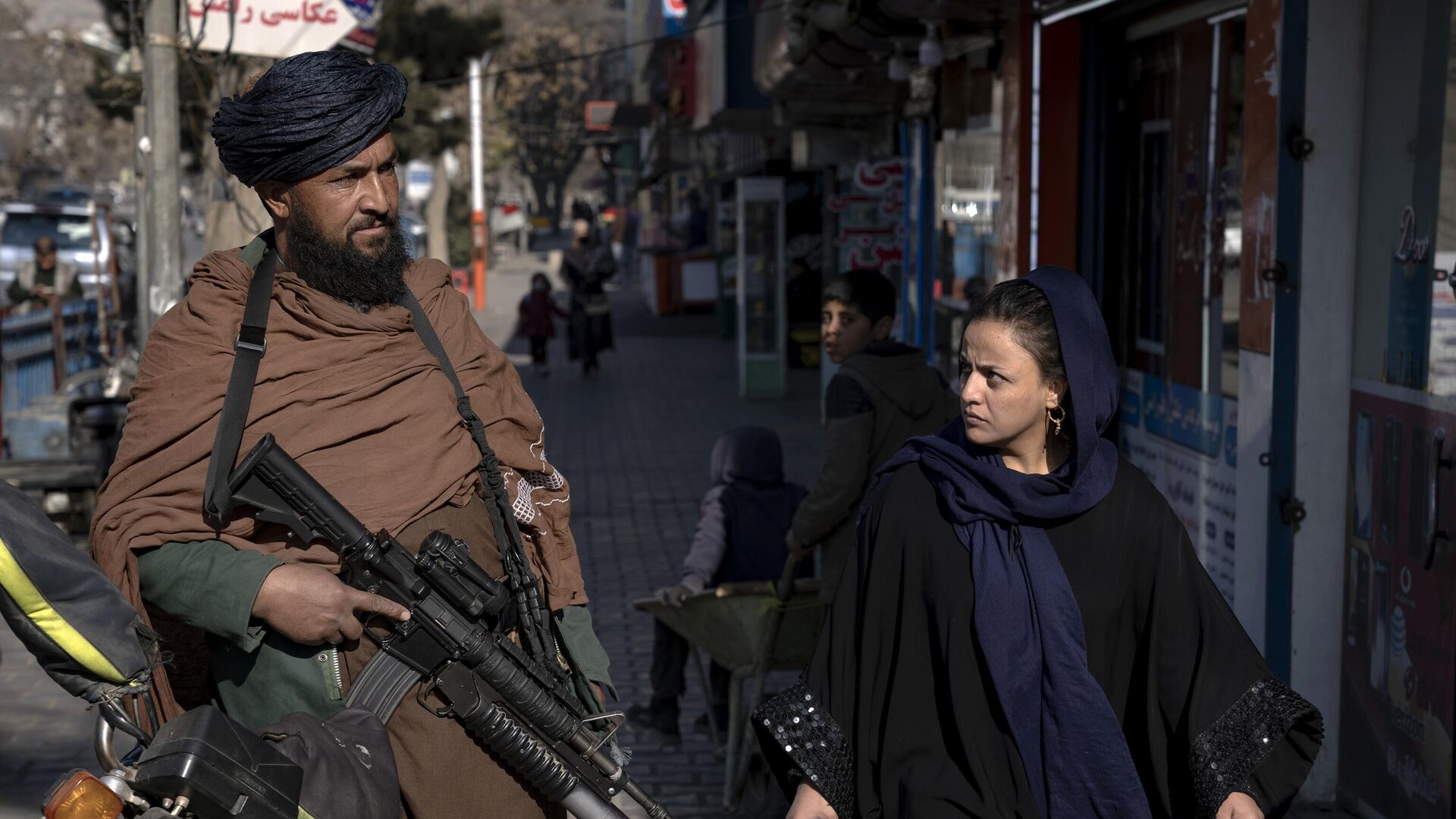 Người phụ nữ nhìn chiến binh Taliban trên đường phố ở Kabul, Afghanistan. - Sputnik Việt Nam, 1920, 22.08.2023