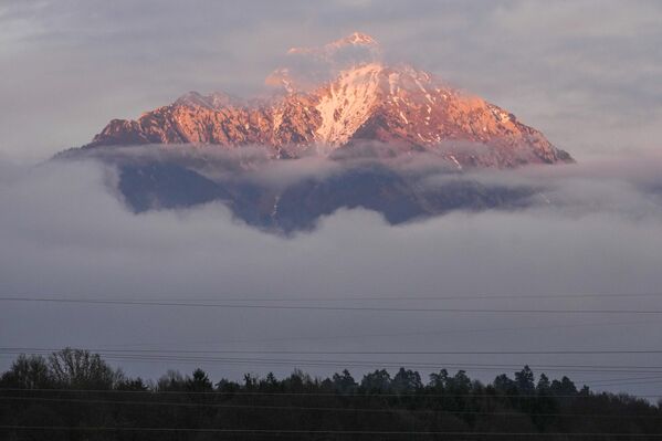 Một đỉnh núi thường bị tuyết bao phủ phía trên ngôi làng Naklo, Slovenia. - Sputnik Việt Nam