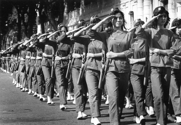 Các nữ quân nhân giơ tay chào khi diễu hành ngang qua bà Trần Lệ Xuân, Đệ nhất phu nhân Việt Nam Cộng hòa, trong buổi lễ tốt nghiệp tại học viện quân sự ở Sài Gòn, năm 1963. - Sputnik Việt Nam