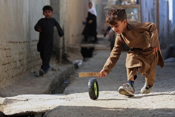 Cậu bé Afghanistan chơi với lốp xe bên ngoài ở Jalalabad. - Sputnik Việt Nam