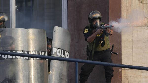 Một cảnh sát bắn hơi cay để giải tán những người ủng hộ Tổng thống bị lật đổ Pedro Castillo ở Lima, Peru - Sputnik Việt Nam
