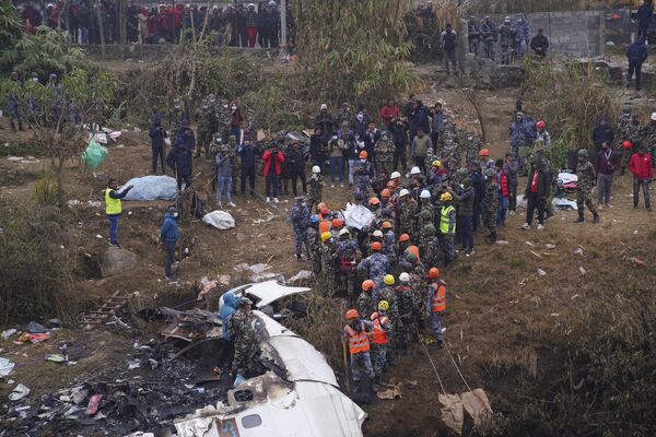 Lực lượng cứu hộ rà soát hiện trường vụ rơi máy bay chở khách ở Pokhara, Nepal. - Sputnik Việt Nam