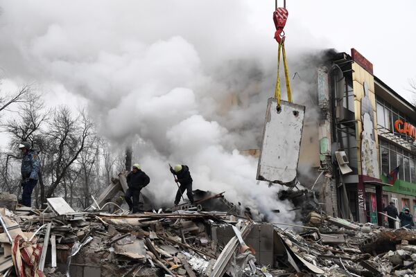 Lực lượng cứu hộ tạihiện trường trung tâm mua sắm bị LLVT Ukraina pháo kích phá hủy ở Donetsk, Nga. - Sputnik Việt Nam