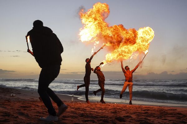Thanh niên Palestine trình diễn kỹ năng phun lửa trên bãi biển ở thành phố Gaza, Palestine. - Sputnik Việt Nam
