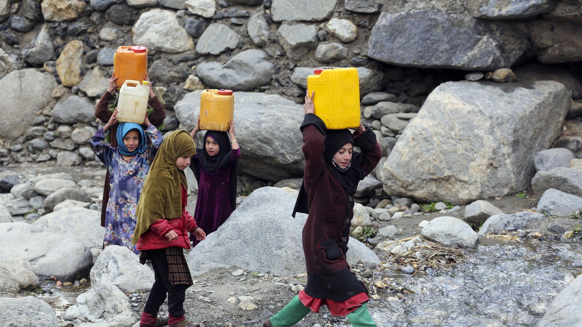 Trẻ em mang những lon nước uống sau khi được đổ đầy từ một con suối ở huyện Dara-e-Noor, tỉnh Nangarhar, Afghanistan. - Sputnik Việt Nam, 1920, 09.02.2023