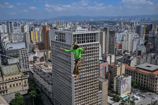 Vận động viên đi dây người Brazil Rafael Bridy băng qua Thung lũng Anangabau trên đoạn đường dài 510 mét ở độ cao 114 mét trong khuôn khổ lễ kỷ niệm 469 năm thành lập thành phố São Paulo, Brazil. - Sputnik Việt Nam