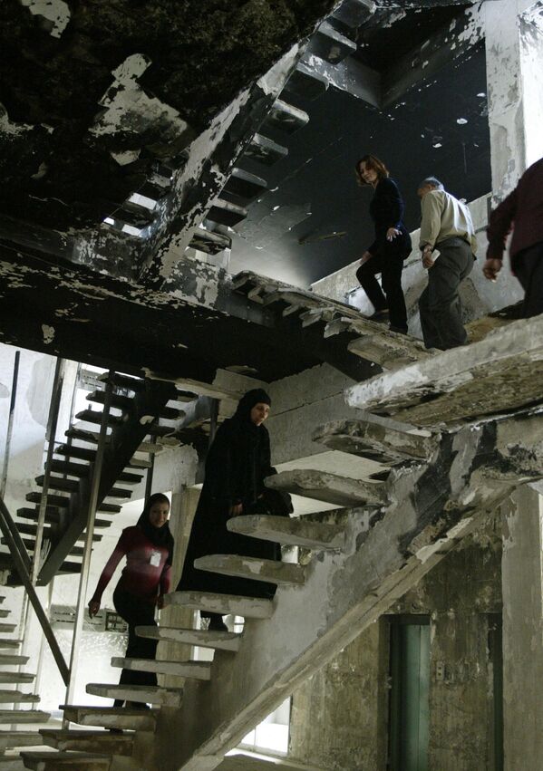 Các nhân viên Thư viện Al-Muthanna ở Baghdad leo lên cầu thang bên trong một khu vực bị cháy và bị cướp bên trong tòa nhà, 2004. - Sputnik Việt Nam