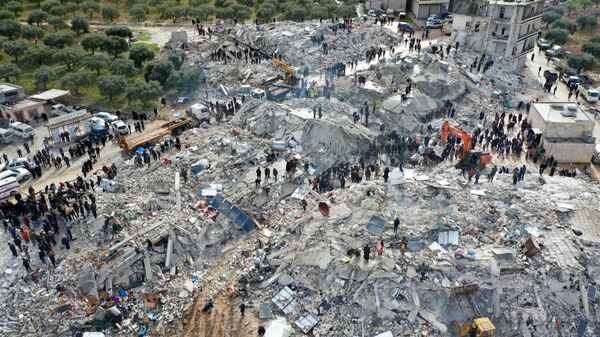 Công việc tìm kiếm nạn nhân và những người sống sót trong đống đổ nát của các tòa nhà bị sập sau trận động đất ở làng Besnia gần thành phố Harim, tỉnh Idlib của Syria - Sputnik Việt Nam