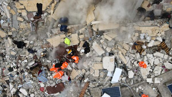 Công việc tìm kiếm nạn nhân và những người sống sót trong đống đổ nát của các tòa nhà bị sập sau trận động đất ở làng Besnia gần thành phố Harim, tỉnh Idlib của Syria - Sputnik Việt Nam