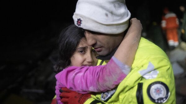 Sĩ quan cảnh sát Zekeria Yildiz ôm con gái sau khi cô bé được giải cứu khỏi đống đổ nát ở Hatay, Thổ Nhĩ Kỳ. - Sputnik Việt Nam