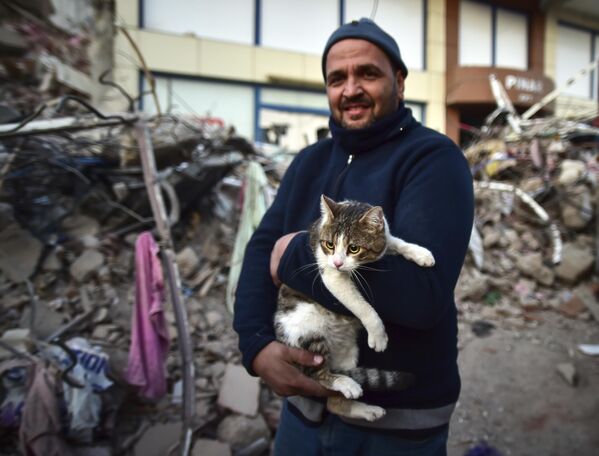 Người đàn ông ôm con mèo của mình, được giải cứu khỏi tòa nhà bị sập, ở Thổ Nhĩ Kỳ. - Sputnik Việt Nam