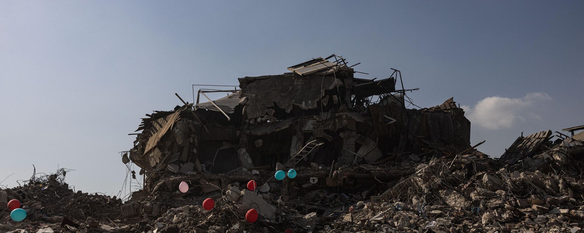 Những quả bóng bay màu đỏ treo trên đống đổ nát những tòa nhà bị sập như biểu tượng của đồ chơi cuối cùng của những đứa trẻ thiệt mạng trong trận động đất ở thành phố Antakya, Thổ Nhĩ Kỳ. - Sputnik Việt Nam, 1920, 26.02.2023