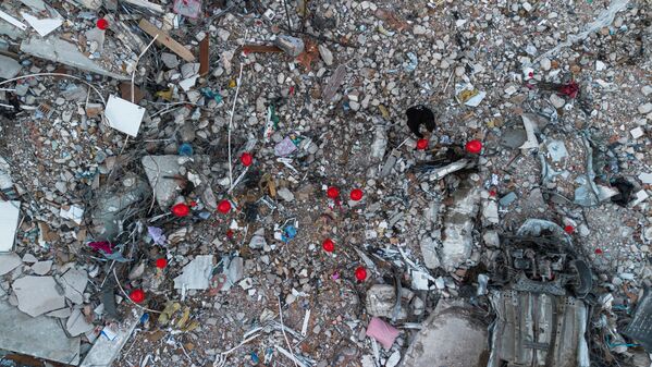 Những quả bóng bay màu đỏ treo trên đống đổ nát các tòa nhà bị sập như biểu tượng &quot;đồ chơi cuối cùng&quot; của những đứa trẻ thiệt mạng trong trận động đất ở thành phố Antakya, Thổ Nhĩ Kỳ. - Sputnik Việt Nam
