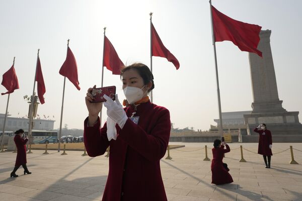 Một nhân viên xe buýt chụp ảnh trước khi khai mạc phiên họp đầu tiên Ủy ban Quốc gia Hội đồng Hiệp thương Chính trị Nhân dân Trung Quốc tại Đại lễ đường Nhân dân Bắc Kinh. - Sputnik Việt Nam