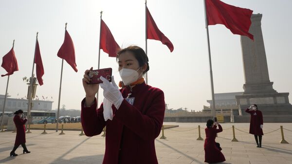 Một nhân viên xe buýt chụp ảnh trước khi khai mạc phiên họp đầu tiên Ủy ban Quốc gia Hội đồng Hiệp thương Chính trị Nhân dân Trung Quốc tại Đại lễ đường  Nhân dân Bắc Kinh. - Sputnik Việt Nam