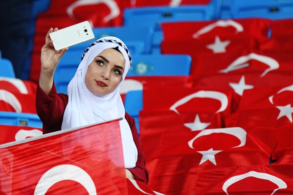 Nữ cổ động viên Thổ Nhĩ Kỳ chụp ảnh trên khán đài trước khi trận đấu bắt đầu. - Sputnik Việt Nam