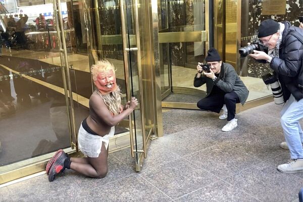 Một phụ nữ đeo mặt nạ Donald Trump và quấn tã lót trong cuộc biểu tình bên ngoài Tháp Trump ở New York. - Sputnik Việt Nam