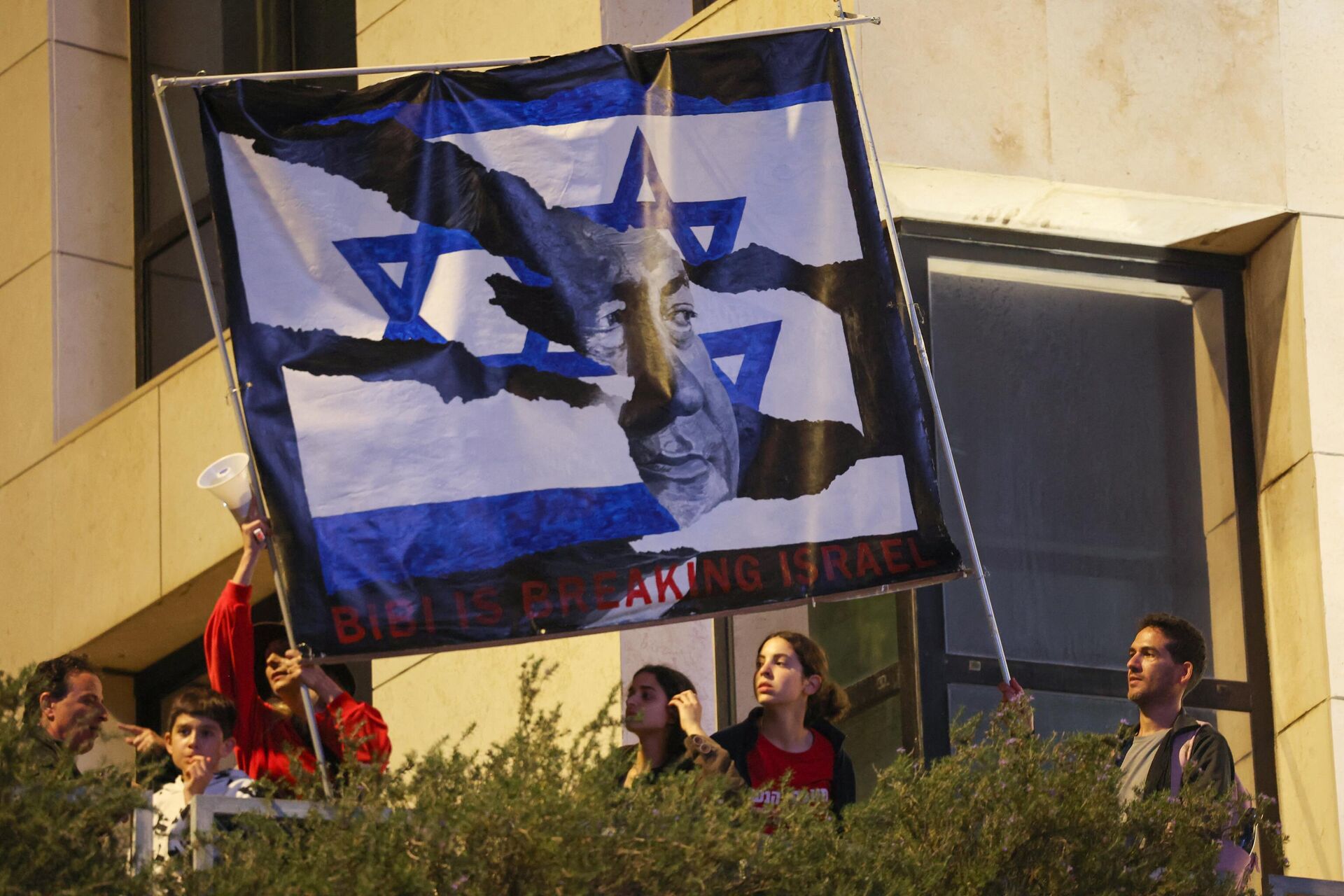 Những người biểu tình ở Israel giương cao biểu ngữ có hình Thủ tướng Benjamin Netanyahu trong một cuộc biểu tình phản đối dự luật đại tu hệ thống tư pháp ở Tel Aviv, ngày 25 tháng 3 năm 2023 - Sputnik Việt Nam, 1920, 29.03.2023