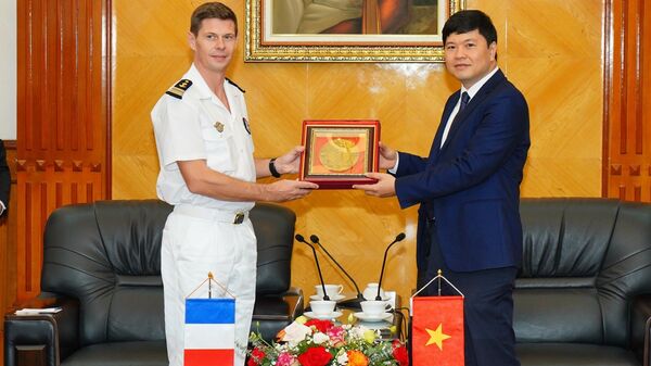 Phó Chủ tịch UBND thành phố Hoàng Minh Cường và Đại tá Francois Maignan - Thuyền trưởng tàu Hải quân Cộng hoà Pháp trao quà lưu niệm - Sputnik Việt Nam