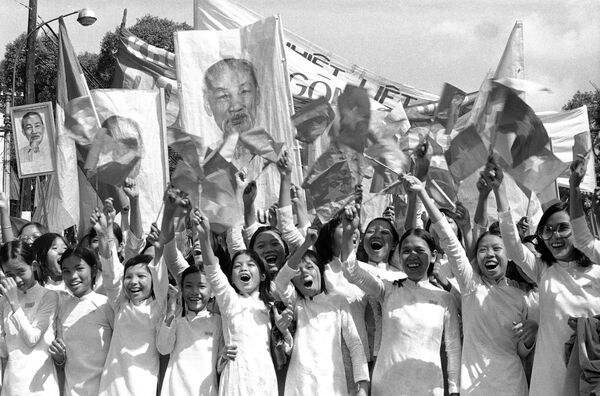 Các thiếu nữ bên chân dung Chủ tịch Hồ Chí Minh ở Sài Gòn. - Sputnik Việt Nam