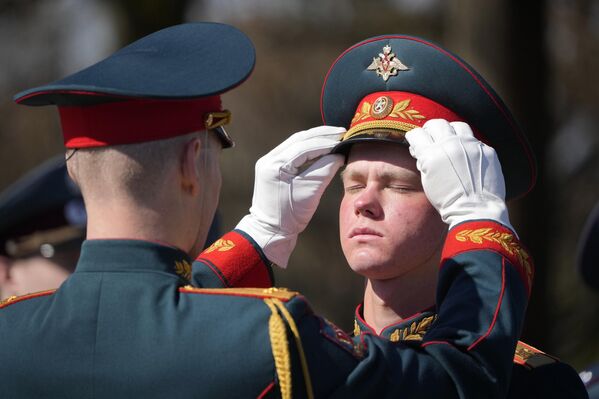 Sĩ quan đội danh dự chỉnh lại mũ của một người lính trong buổi lễ đặt hoa và vòng hoa tại nghĩa trang Piskarevsky ở St. Petersburg. - Sputnik Việt Nam