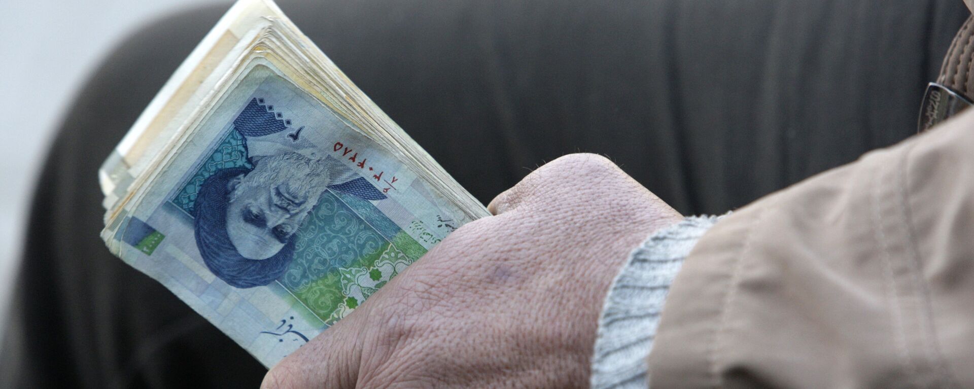 Người đổi tiền trên đường phố Iran giữ tiền giấy của Iran - Sputnik Việt Nam, 1920, 23.05.2023