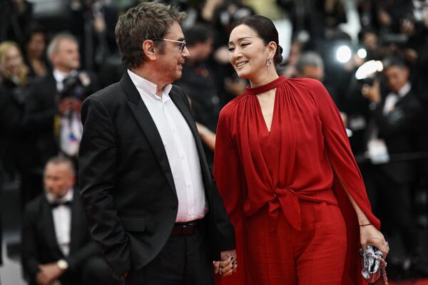 Nhà soạn nhạc người Pháp Jean-Michel Jarre (trái) và vợ - nữ diễn viên Trung Quốc Củng Lợi, tại Liên hoan phim Cannes lần thứ 76, Pháp. - Sputnik Việt Nam