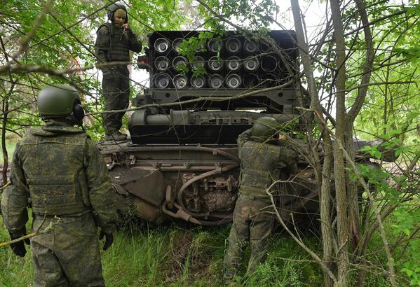 Thành viên tổ điều khiển bên gần hệ thống súng phun lửa hạng nặng TOS-1A Solntsepyok của Lực lượng Vũ trang Nga trong khu vực diễn ra chiến dịch quân sự đặc biệt. - Sputnik Việt Nam