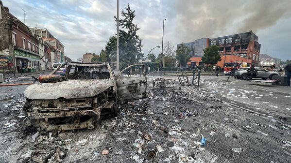 Một chiếc ô tô và một tòa nhà bị thiêu rụi sau các cuộc biểu tình ở thành phố Roubaix của Pháp - Sputnik Việt Nam