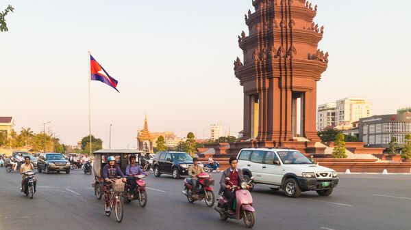 Người lái ô tô và xe máy chạy vòng quanh Tượng đài Độc lập ở trung tâm thủ đô Phnom Penh, Campuchia - Sputnik Việt Nam
