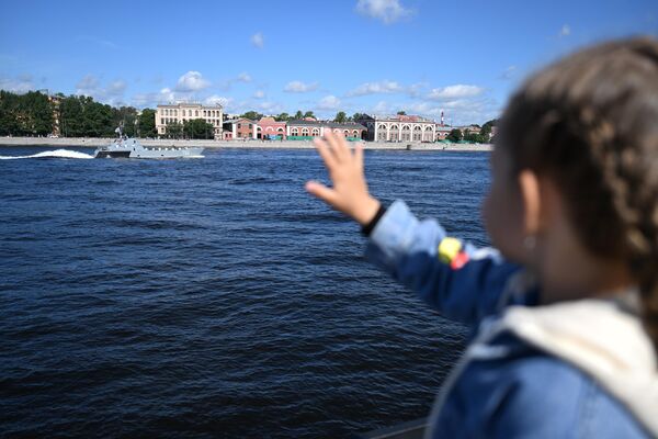 Một cô gái trên bờ kè Neva theo dõi đội hình các con tàu tại cuộc diễu hành đánh dấu Ngày Hải quân Nga ở St. Petersburg. - Sputnik Việt Nam