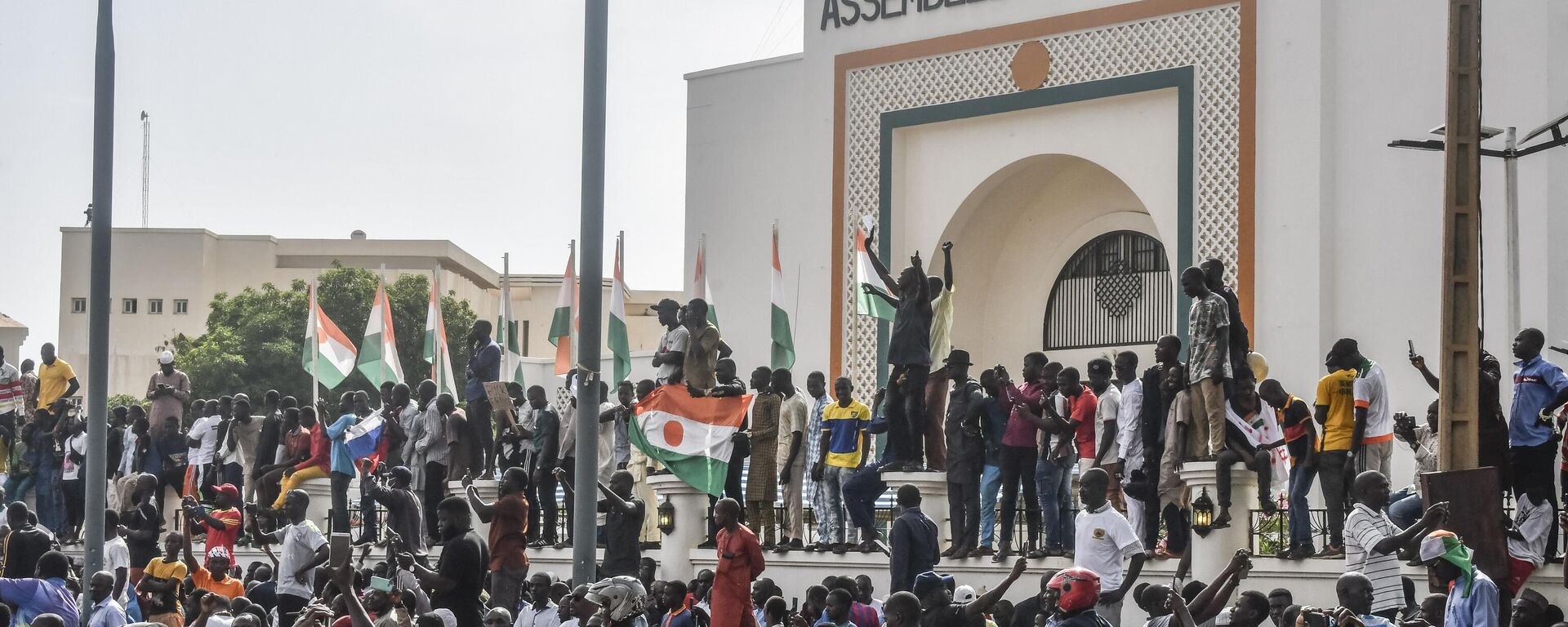 Những người ủng hộ vẫy cờ Nigeria trong cuộc tập hợp để ủng hộ chính quyền Nigeria trước tòa nhà Quốc hội ở Niamey - Sputnik Việt Nam, 1920, 03.08.2023