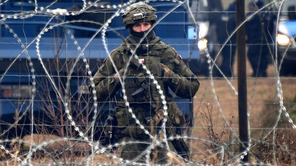 Một người lính Ba Lan đứng gác sau hàng rào thép gai ở biên giới với Belarus - Sputnik Việt Nam