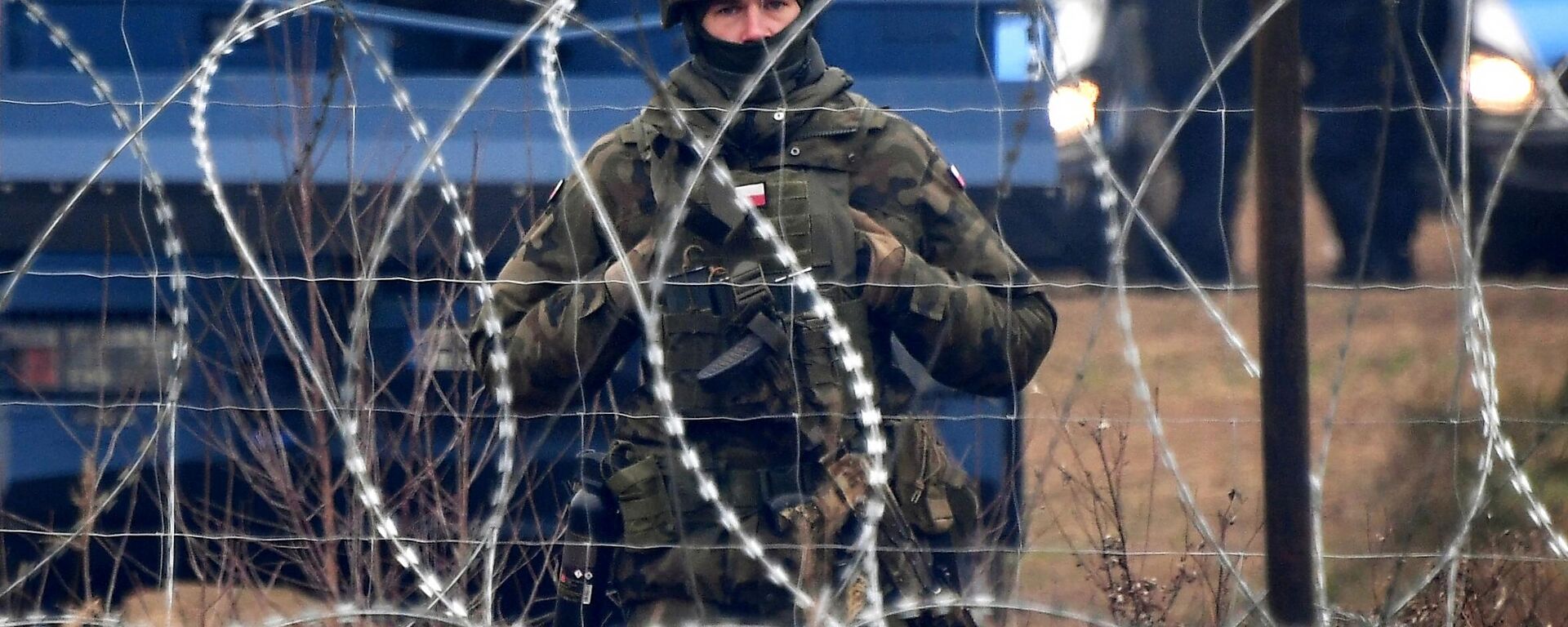 Một người lính Ba Lan đứng gác sau hàng rào thép gai ở biên giới với Belarus - Sputnik Việt Nam, 1920, 08.08.2023